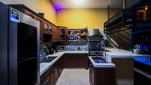 Una cocina con armarios de madera oscura, microondas empotrado y estufa a gas.