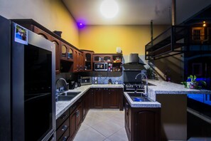 Una cocina con armarios de madera oscura, microondas empotrado y estufa a gas.