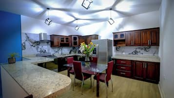 Una cocina moderna con encimeras de granito, armarios de madera y una isla central con asientos.