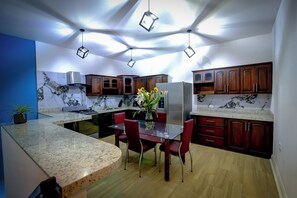 A modern kitchen with granite countertops, wooden cabinets, and a central island with seating.