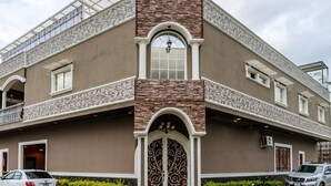 Un edificio con una entrada de arco destacada, un balcón y cielo despejado.