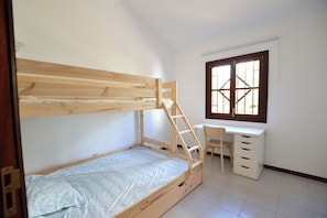 Ein Schlafzimmer mit einem Etagenbett, einem Schreibtisch und einem Stuhl.