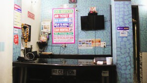 A reception area with a sign listing services like air tickets and car rentals.