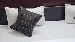 A bed with white bedding and a dark headboard.