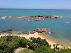 En la playa, arena blanca, sillas reclinables de playa, sombrillas