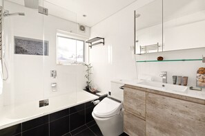 A modern bathroom with a toilet, sink, and shower. - Peaceful Hideaway 2-Bed Apartment Mosman (Mosman)