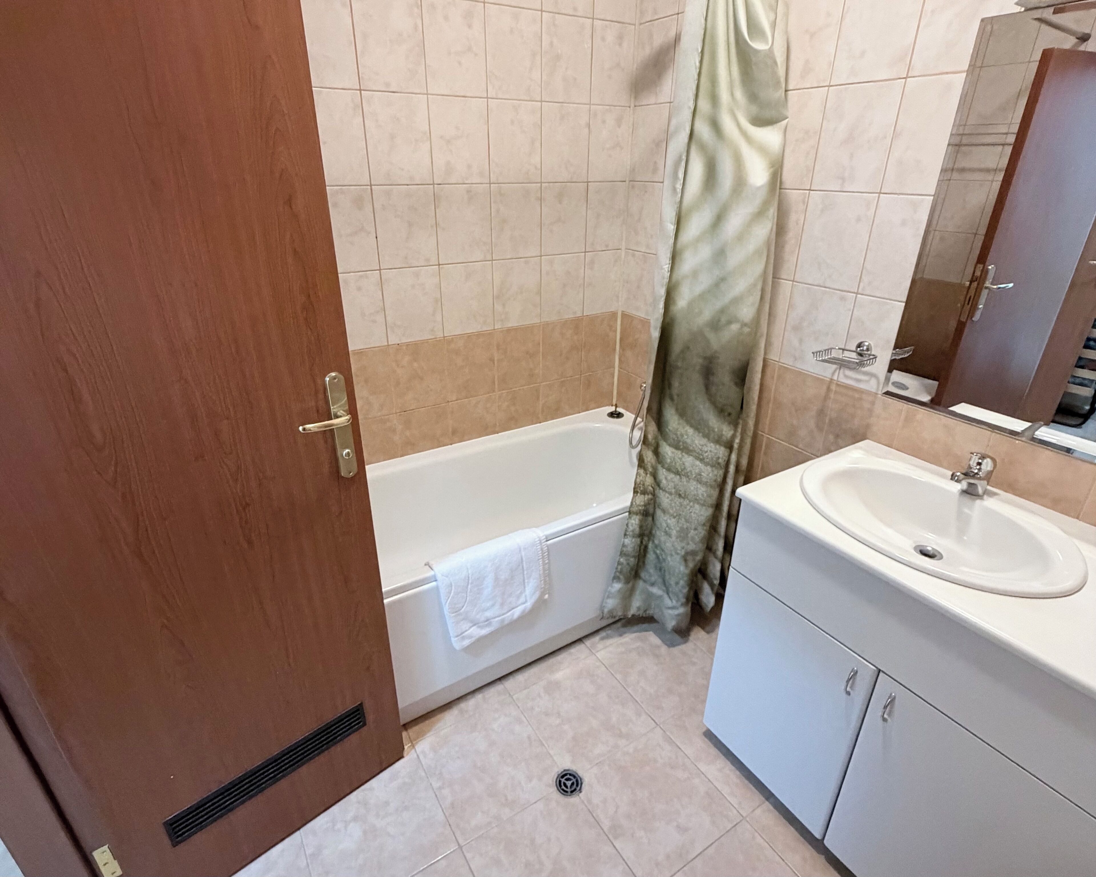 Ein Badezimmer mit Badewanne, Waschbecken und Spiegel.