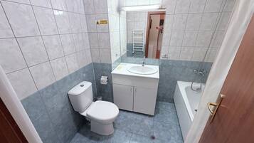 Ein Badezimmer mit Toilette, Waschbecken und Badewanne.