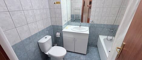 A bathroom with a toilet, sink, and bathtub.