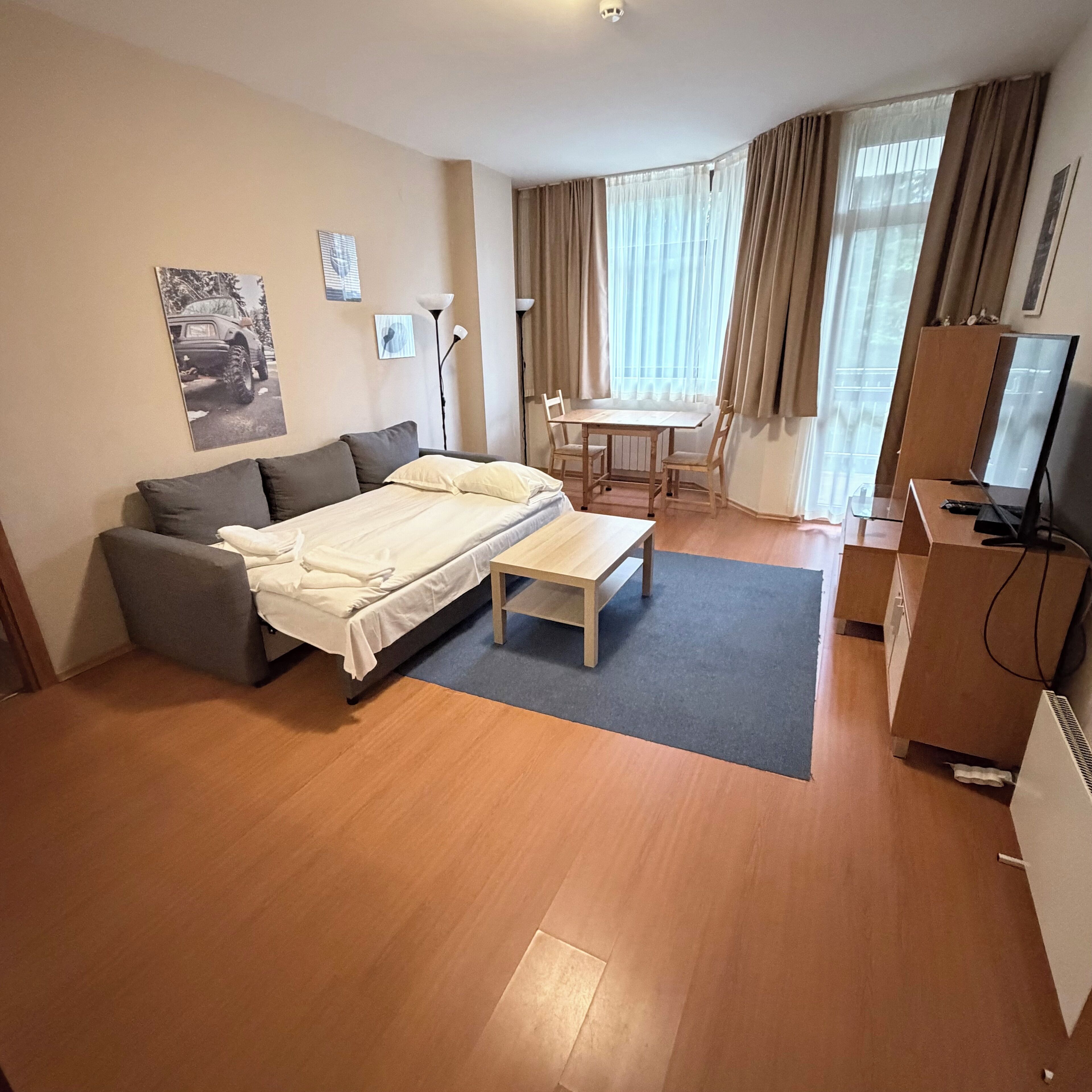 Una habitación de hotel moderna con cama, sofá, escritorio y televisión.