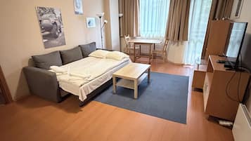 Una habitación de hotel moderna con cama, sofá, escritorio y televisión.