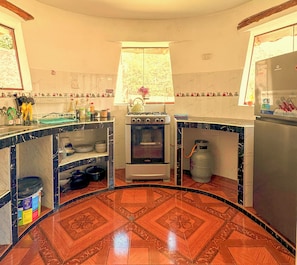A kitchen with a gas stove, oven, and a refrigerator.