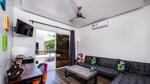 A modern living room with a sofa, coffee table, and a television mounted on the wall.