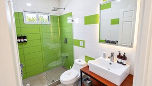Et moderne badeværelse med bruser, toilet og håndvask.