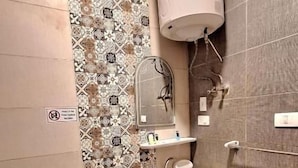 Casa de banho com sanita, lavatório e chuveiro.