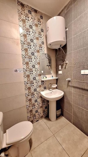 Ein Badezimmer mit Toilette, Waschbecken und Dusche.