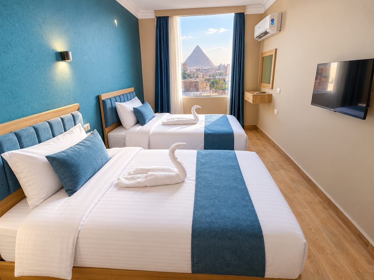A hotel room with two beds, a TV, an air conditioning unit, and a view of a pyramid.