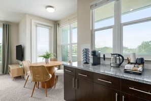 A modern kitchen with a dining area, large windows, and a coffee maker. - Palm Luxury Huge 2br/2ba Pool/Gym Downtown Tampa (Tampa)