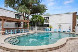 A swimming pool with a sun deck, lounge chairs, and a bar area. - 2BR Downtown Tampa Resort Retreat with Pool (Tampa)