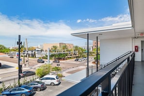 A view from a balcony overlooking a busy intersection with cars and buildings in the distance. - UTampa - Downtown Studio Next to UT and Riverwalk (Tampa)