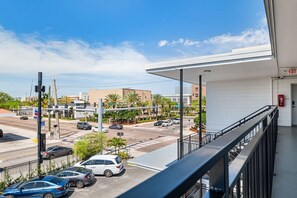 A hotel balcony with a view of a busy intersection, a fire extinguisher, and a clear sky. - Stylish Studio w/ BBQ & Outdoor Oasis (Tampa)