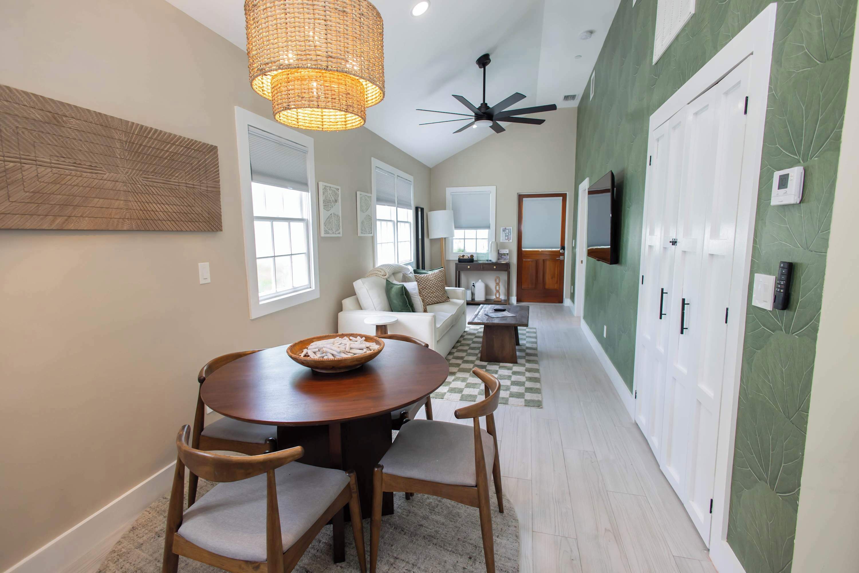 A spacious living area with a dining table, chairs, a sofa, and a television.