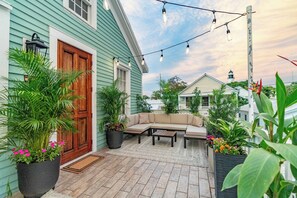 A patio with a sofa, a coffee table, and potted plants. - Tortugas Harbor Light Suite (Key West)