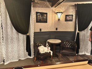 A room with patterned wallpaper, a dark wooden bench, a round table, and a dog resting on the bench. - Stunning Chalet 5-bedroom house in peaceful Lake Harmony with AC (Lake Harmony)