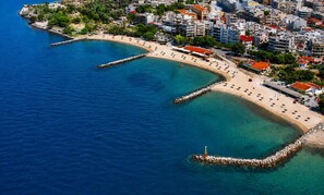 An aerial view of a coastal city with a beach, buildings, and a clear blue sea. - Mountain Breeze Sanctuary With View Near Volos (Volos)