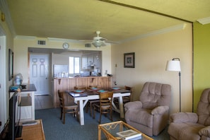 A compact living space with a dining area, kitchen, and a seating area with a sofa and armchair. - Harder Hall Resort Club by CoolVacay (Sebring)