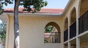 A building with a red-tiled roof, a beige facade, and a balcony with black railings. - Harder Hall Resort Club by CoolVacay (Sebring)