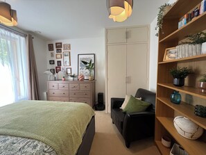 Une chambre à coucher comprenant un lit, une commode, une bibliothèque et une armoire.