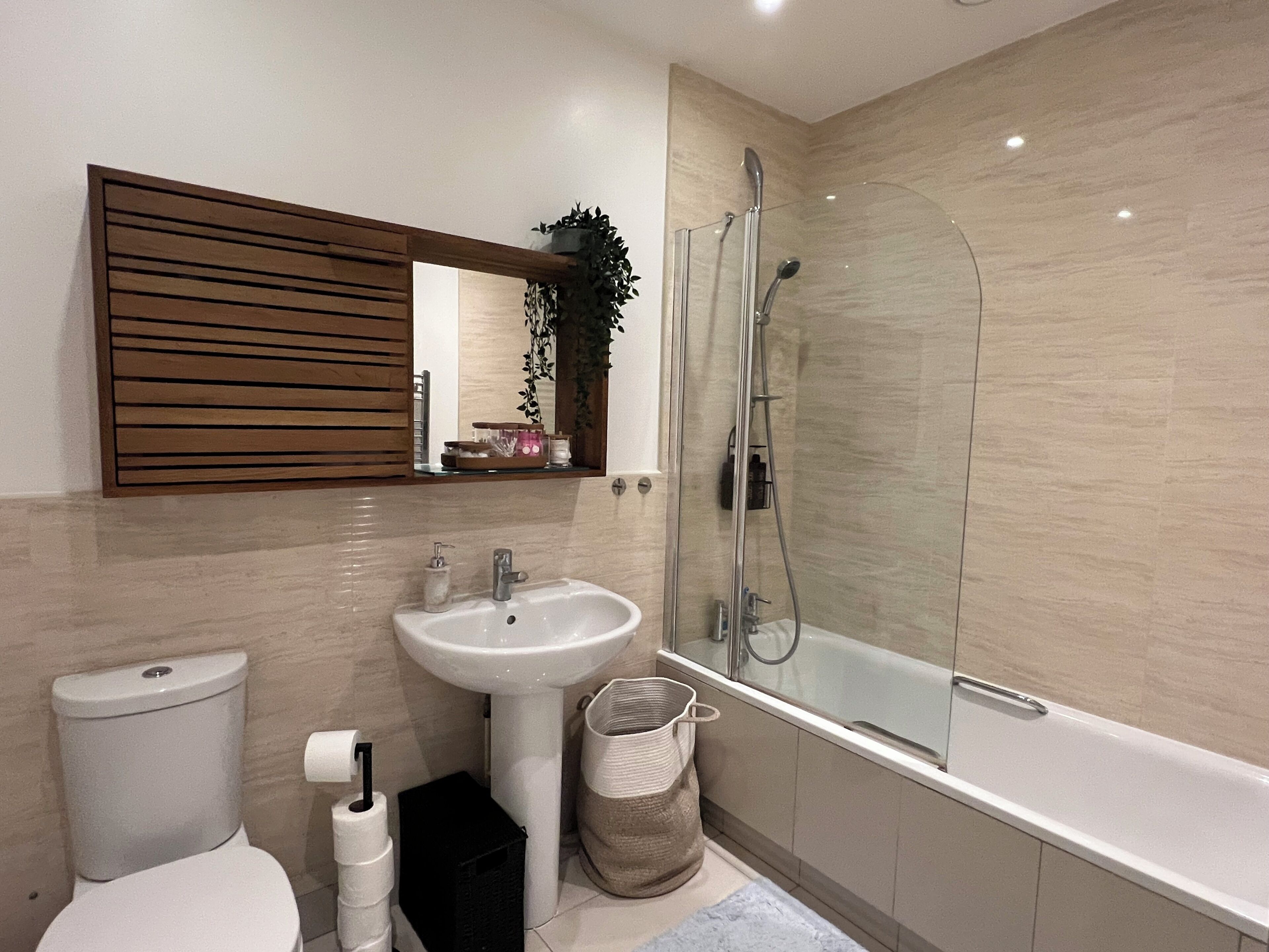 Ein modernes Badezimmer mit Toilette, Waschbecken und einer Glasdusche.