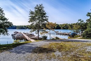 A lakeside dock area with boats, a covered walkway, and a grassy foreground.
