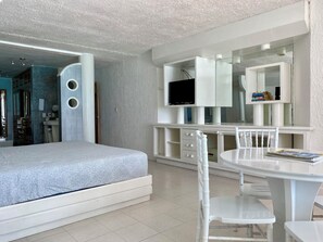 Ein modernes Schlafzimmer mit einem Bett, einem Schreibtisch, einem Stuhl und einem Fernseher.