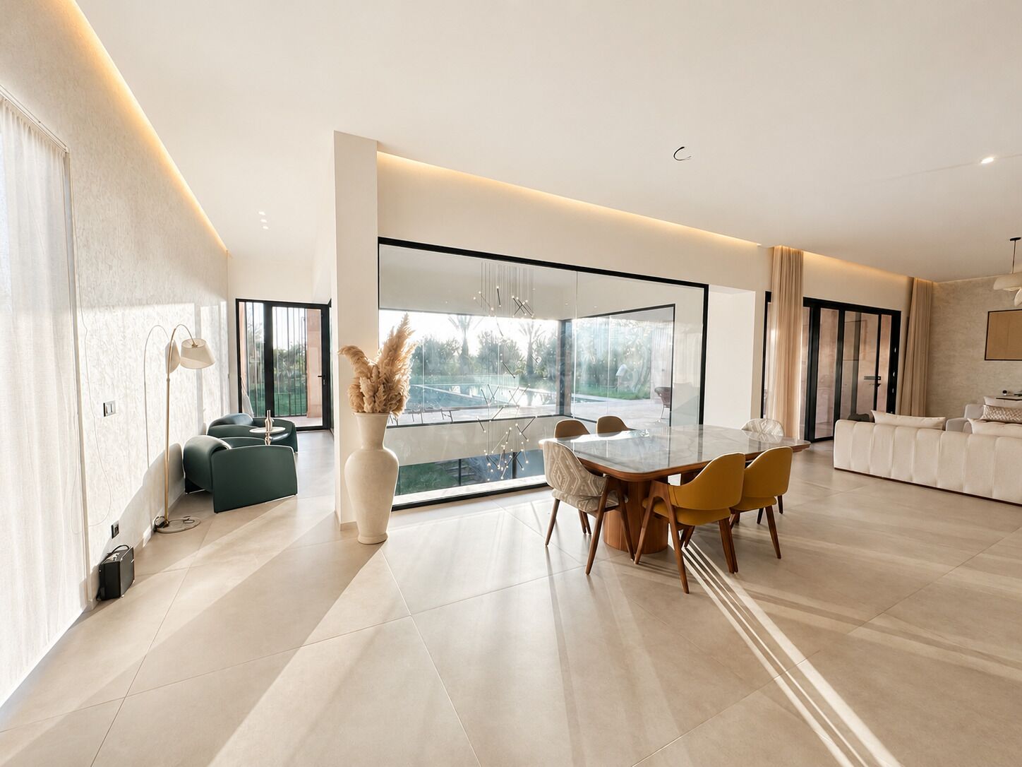 Ein modernes Wohnzimmer mit Essbereich, großen Fenstern und Blick ins Freie.