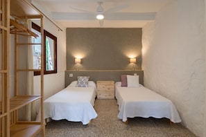 A small, compact room with two single beds, a wooden wardrobe, a ceiling fan, and two wall-mounted lamps. - Sa Marina by Rentallorca (Son Serra de Marina)