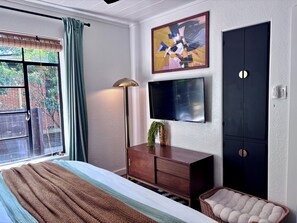 A bedroom with a bed, a dresser, a television, and a window with curtains. - 2 bed 1 bath bungalow in Central Austin. Pet friendly! Minutes to Downtown. (Austin)