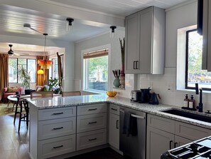 A modern kitchen with white cabinets, a granite countertop, and stainless steel appliances. - 2 bed 1 bath bungalow in Central Austin. Pet friendly! Minutes to Downtown. (Austin)