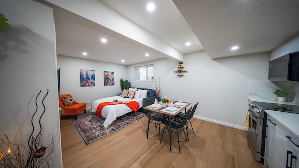 A modern apartment with a dining area, kitchen, and living space.