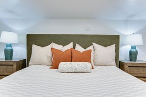 A neatly made bed with a patterned bedspread, flanked by two nightstands with lamps and decorative vases. - Lakeside Home w/Private Casita & Stunning Views (San Angelo)