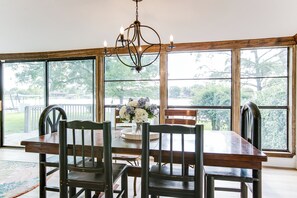 A dining area with a wooden table, chairs, and a chandelier. - Lakeside Home w/Private Casita & Stunning Views (San Angelo)