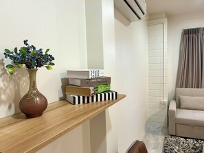 A wooden shelf with a potted plant and a stack of books. - 3-bedroom house in adorable Chalong Phuket with nestled among lush mature trees (Tambon Chalong)
