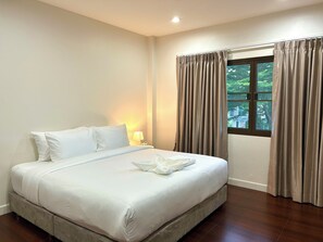 A neatly made bed with white linens, a bedside lamp, and a window with curtains. - 3-bedroom house in adorable Chalong Phuket with nestled among lush mature trees (Tambon Chalong)
