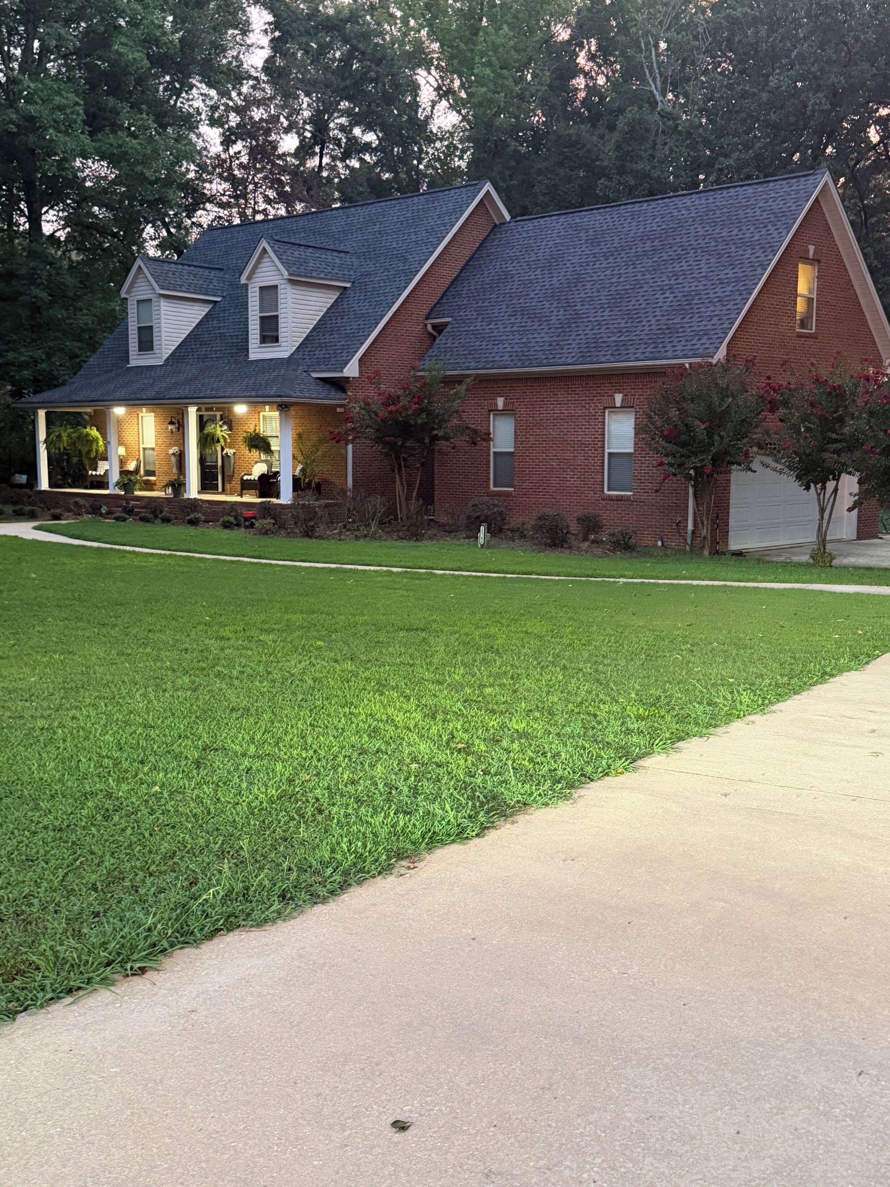 A two-story house with a covered porch and a garage.