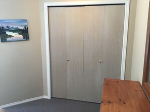A closed door with a white frame, a grey carpeted floor, and a wooden bench to the right. - Ski in Ski out condo in Whistler. Just a 3 minute walk from the upper village. (Whistler)