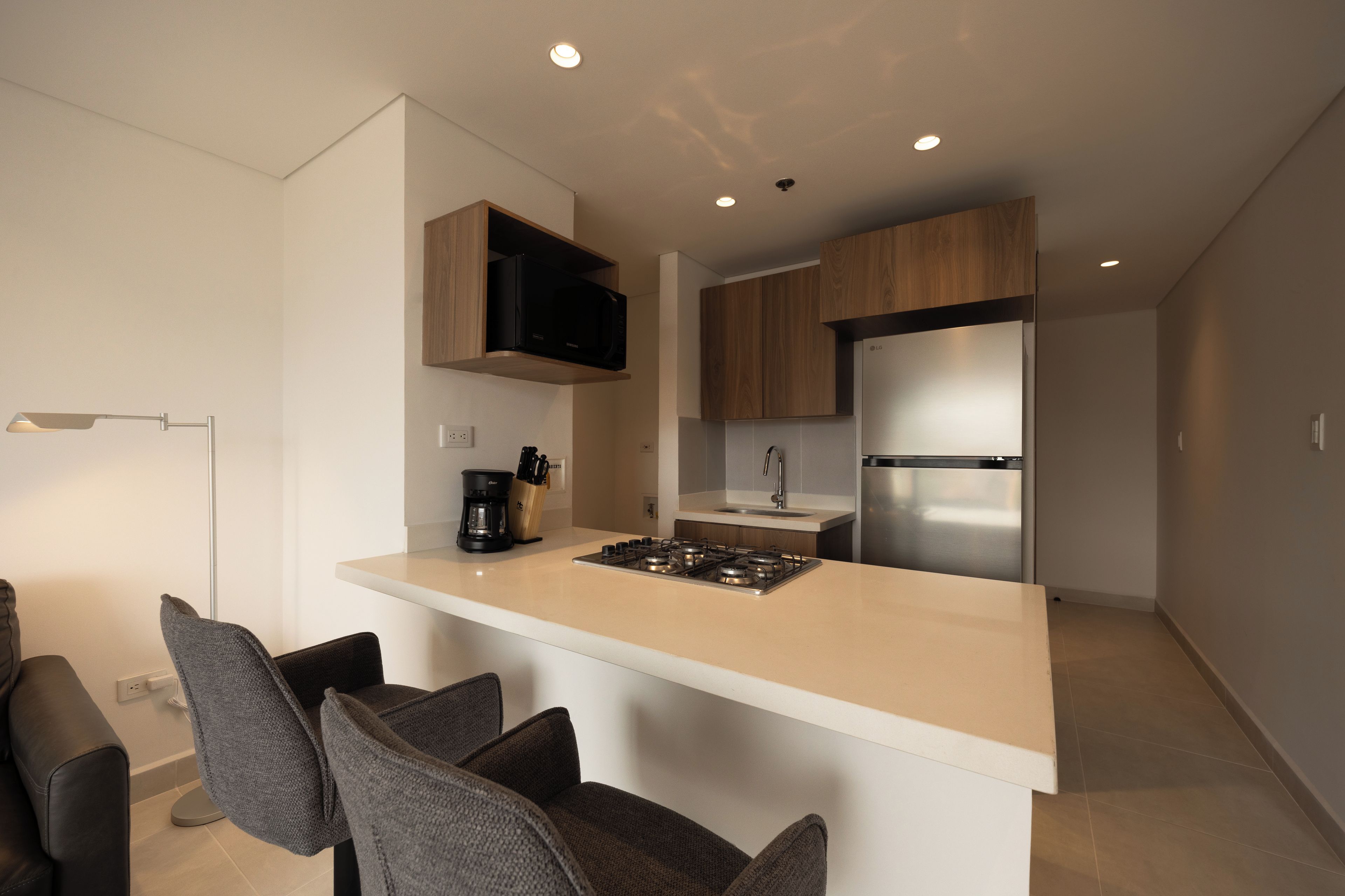 A modern kitchen with a central island, built-in appliances, and bar seating.