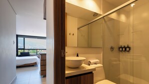 A modern bathroom with a glass shower enclosure, a large sink, and a toilet. - VENTO MOLINO (BELEN)