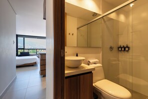 A modern bathroom with a glass shower enclosure, a large sink, and a toilet. - VENTO MOLINO (BELEN)