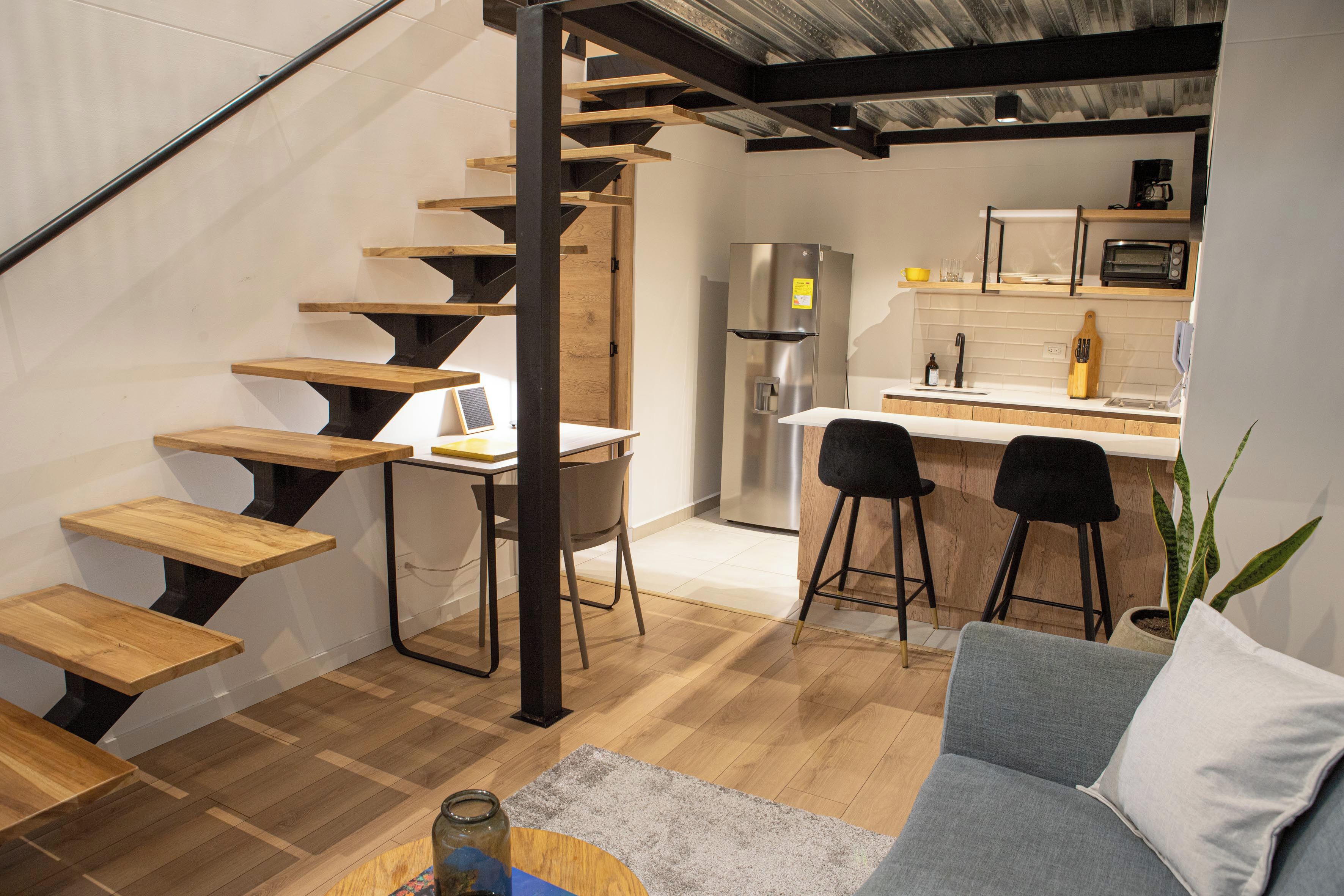 A modern kitchen with a built-in refrigerator, a microwave, and a bar area with stools.